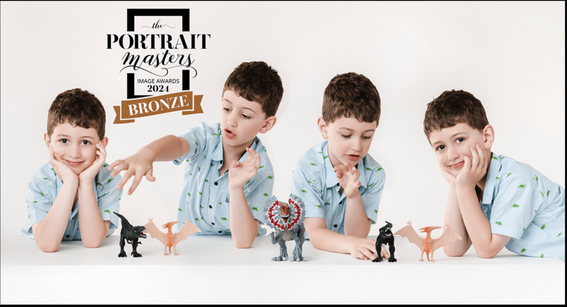 Portrait Masters Bronze award of a boy playing with dinosaurs by Juliette Scott Photography